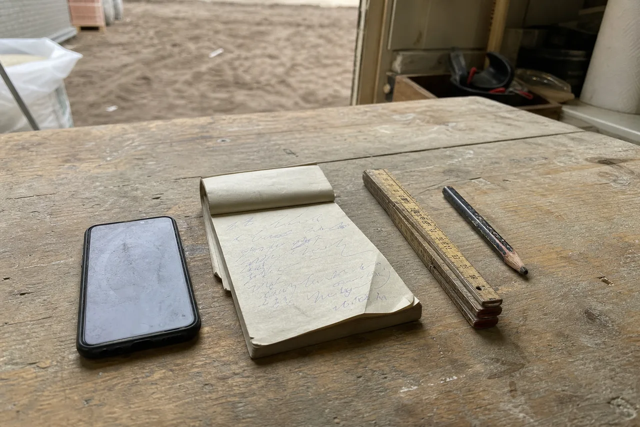 Papieren bonnenboekje met handgeschreven krabbels naast een smartphone op een werkbank — het verschil tussen een papieren en een digitale werkbon